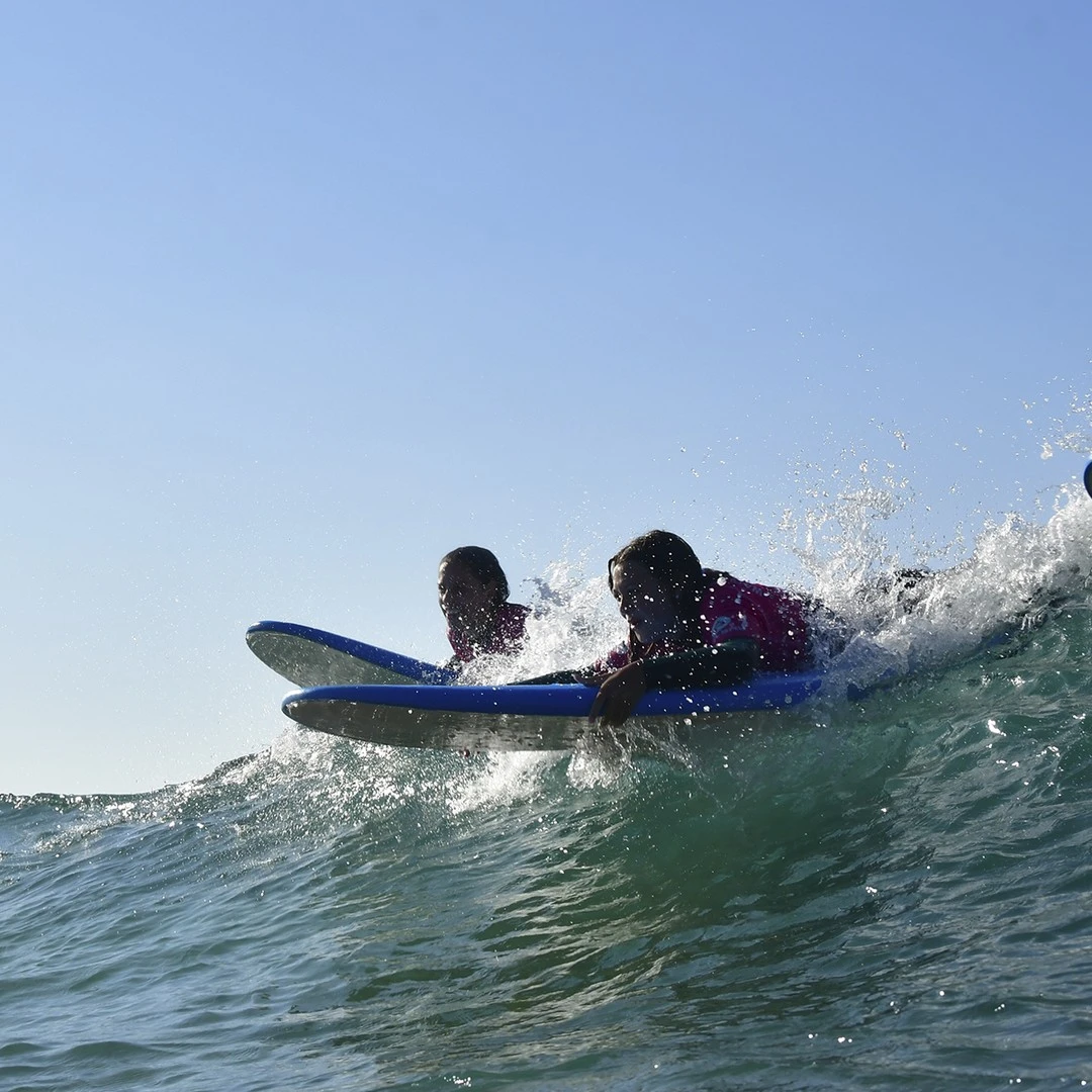 Alumnas en el agua en el campamento surf en Santoña